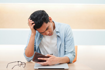 close up asian man open blank wallet with stress emotion after pay debt on end of the month , risk...