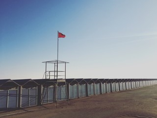 a red flag on a desert beach