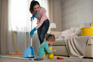 Mom and daughter are cleaning in the apartment