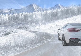 Fototapeta na wymiar SUV driving on a mountain road during falling snow