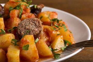 Potatoes stew with pork sausages on plate