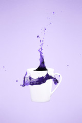Levitating coffee mug with splashes. Coffee concept. Minimal art trend. Solid pink background