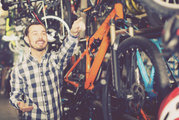 Obraz na płótnie Canvas Man considers bicycle frame in store