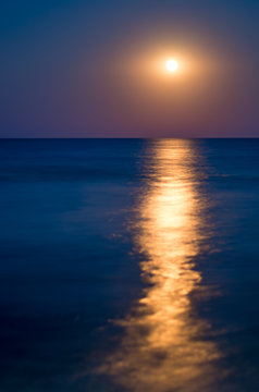 moon in the night blue sky, sea horizon, waves, reflection of light. Vertical composition