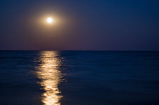 moon in the night blue sky, sea horizon, waves, reflection of light. Horizontal composition