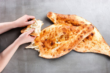 Female hands holding the piece of traditional Georgian flatbread shoti