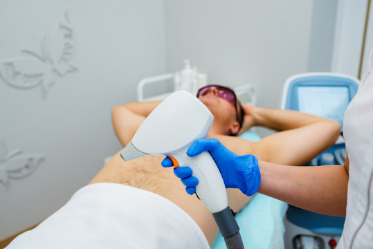 man receiving laser epilation at armpit on beauty center