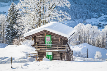 Traditional wooden mountain chalet in scenic winter wonderland scenery in the Alps