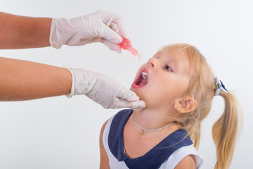 little girl on reception at the doctor receives the polio vaccine,
 - obrazy, fototapety, plakaty
