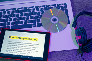Laptop und Tablett auf dem der Text einer Unterlassungserklärung angezeigt wird in englisch...