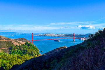 Golden Gate Bridge mit passierendem Transportschiff, San Francisco Skyline im Hintergrund, USA,...