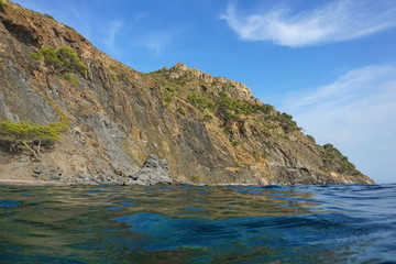 Fototapeta na wymiar Spain Costa Brava coastal landscape cliff seen from water surface, Cap Norfeu, Mediterranean sea, Alt Emporda, Girona, Catalonia