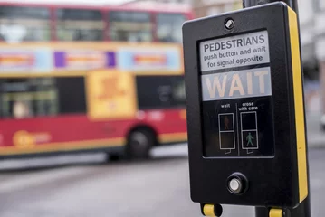 Foto op Plexiglas Crosswalk button for pedestrian, London UK - Wait sign at a traffic light for pedestrian crossing - Pedestrians push button and wait for signal opposite © Brastock Images