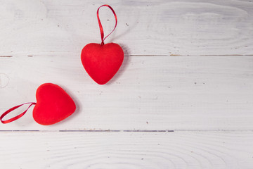 Two red hearts on white wooden background