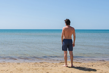 Fototapeta na wymiar Unrecognizable young man looking at the sea.
