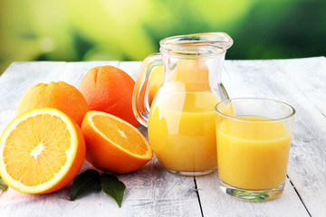 Naklejka na ściany i meble Glass of orange juice and slices of orange fruit on wooden background.