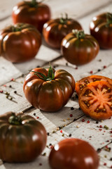 Obraz na płótnie Canvas tomate negro raf, medio tomate. fondo de madera
