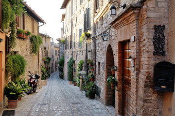 Fototapeta na wymiar Traditional italian medieval alley in the historic center of beautiful little town of Spello, Perugia , in Umbria region - central Italy
