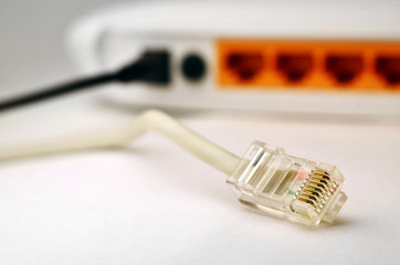 Plug of internet cable on the background of internet router. Macro shot with shallow depth of field and blurred background