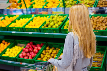 Consumerism concept. Woman doing grocery shopping at supermarket