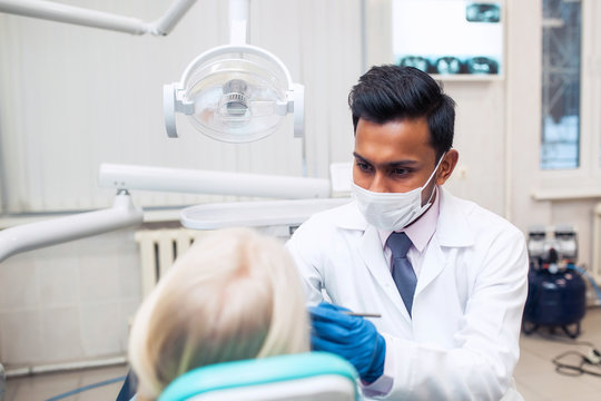friendly dentist conversation patient open mouth during oral checkup with mirror near by, good healthcare in clinic office room concept. Trust in medicine treatment with professional handsome doctor.