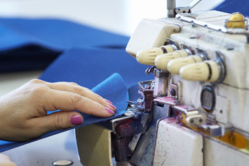 Closeup of a seamstress's work on an overlock in a sewing workshop.