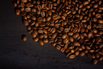 Coffee beans on a black textured background.