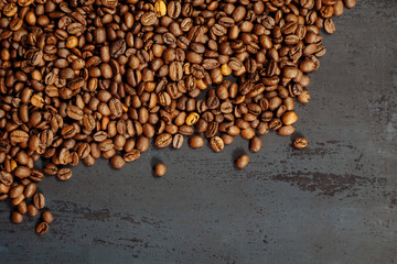 Coffee beans on a black textured background.