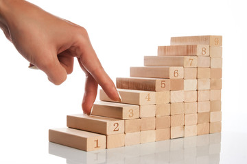 Women hand finger walk on stacked wooden block