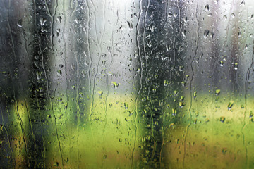 drops of rain on the glass with a view of the park