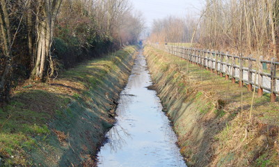 Pista ciclabile e pedonale vicino al canale d'acqua in campagna