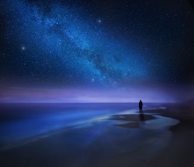 Fototapeta Starry night sky over sea and beach with man silhouette obraz