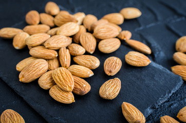 Almonds on the black stone background
