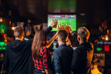 Friends watches football on TV in a sport bar