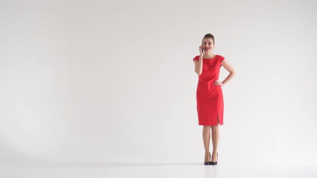 Happy businesswoman in red dress talking on phone