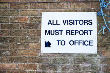 Fototapeta na wymiar All visitors must report to office at workplace sign on wall