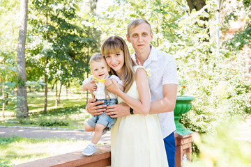 happy family on a walk. Green Garden. Mom, dad and son. Yellow butterfly. Maternal happiness. Daddy's heir. Happy childhood.