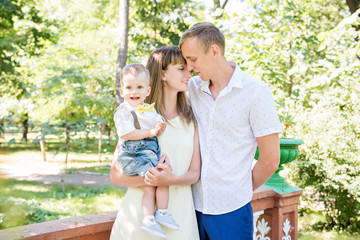 happy family on a walk. Green Garden. Mom, dad and son. Yellow butterfly. Maternal happiness. Daddy's heir. Happy childhood.