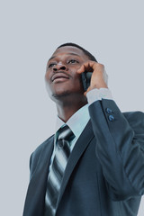 Young entrepreneur holding his coat over shoulder while talking on cell phone.