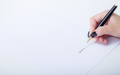 Close up girl hand putting signature on document. She situating at desk. Business concept. Low angle