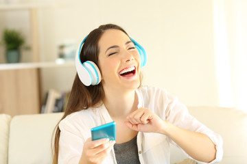 Naklejka premium Happy girl dancing and singing listening to music