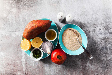ingredients for hot salad from sweet potato, quinoa seeds, onion and ripe pomegranate. vegetarian or vegan lunch or dinner