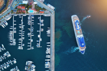 Aerial view of amazing boats and large cruise ship at sunset. Minimalistic landscape with boats and...