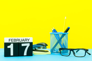 February 17th. Day 17 of february month, calendar on yellow background with office supplies. Winter time