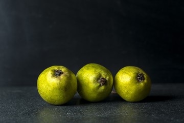 Fototapeta na wymiar Green pears lying on dark background