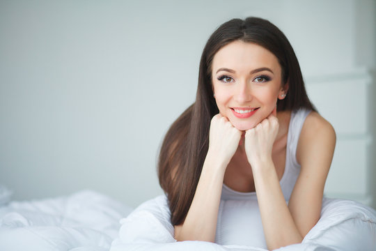 Young woman sleeping on the white bed-clothes in bed at home. Relax night morning rest concept.