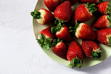 a pile of fresh juicy ripe strawberries on the plate