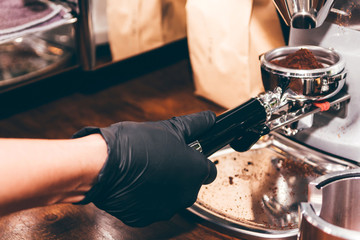 Women Barista using coffee machine for making coffee in the cafe