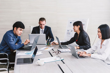 Businesspeople using laptops and discussing together in meeting room.Teamwork concept