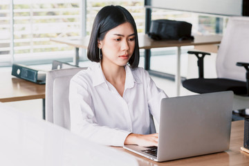 Businesswoman working on notebook computer and business document at office